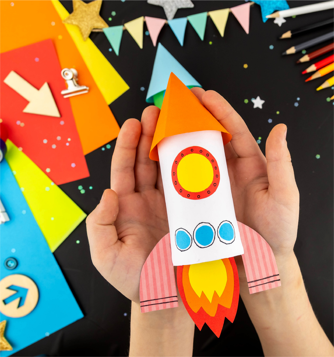 Hand-crafted rocketship with construction paper visible in the background